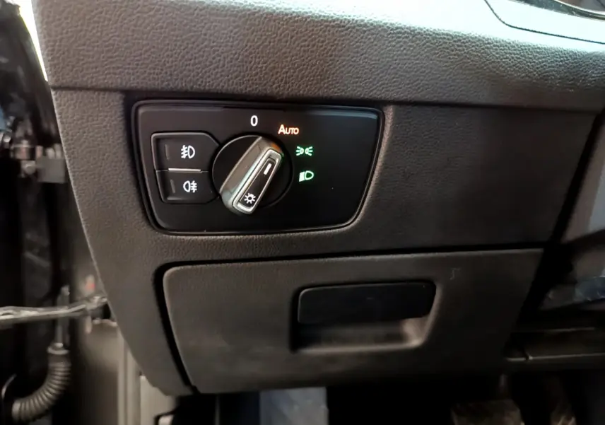 Gros plan sur le bouton de commande des phares dans l'habitacle gris foncé d'une Volkswagen Passat 2021.