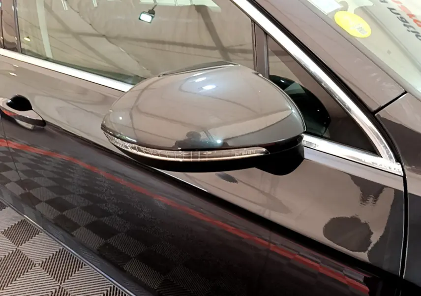 Rétroviseur droit gris foncé de la Volkswagen Passat 2021, avec clignotant intégré, vue rapprochée côté conducteur.