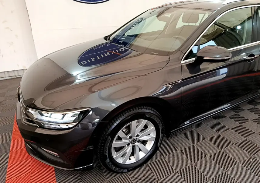 Volkswagen Passat gris foncé vue 3/4 avant droit, phares LED et jantes alliage visibles.