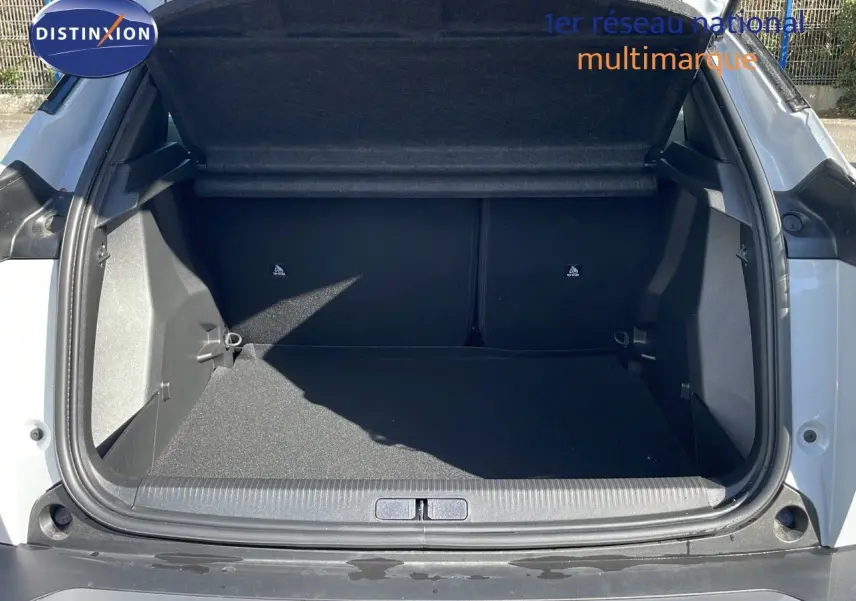 Coffre ouvert d'un Peugeot 2008 blanc Okenite Metal, montrant l'espace de chargement intérieur vide.