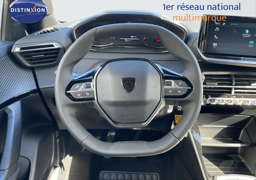 Vue rapprochée du volant multifonction noir et du tableau de bord moderne d'une Peugeot 2008 blanche.