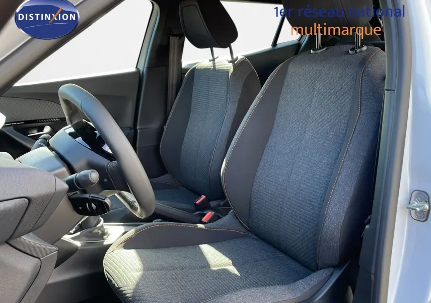 Intérieur de la Peugeot 2008 blanc okenite, vue côté gauche sur les sièges avant en tissu gris avec surpiqûres orange.