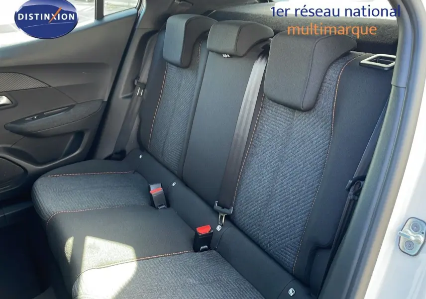 Vue intérieure du siège arrière côté droit d'un Peugeot 2008 blanc Okenite Metal avec sellerie tissu gris et surpiqûres orange.