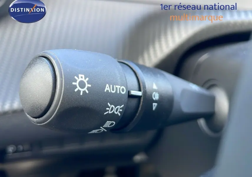 Gros plan sur la commande des phares automatique dans l'habitacle d'une Peugeot 2008 blanche 2025.