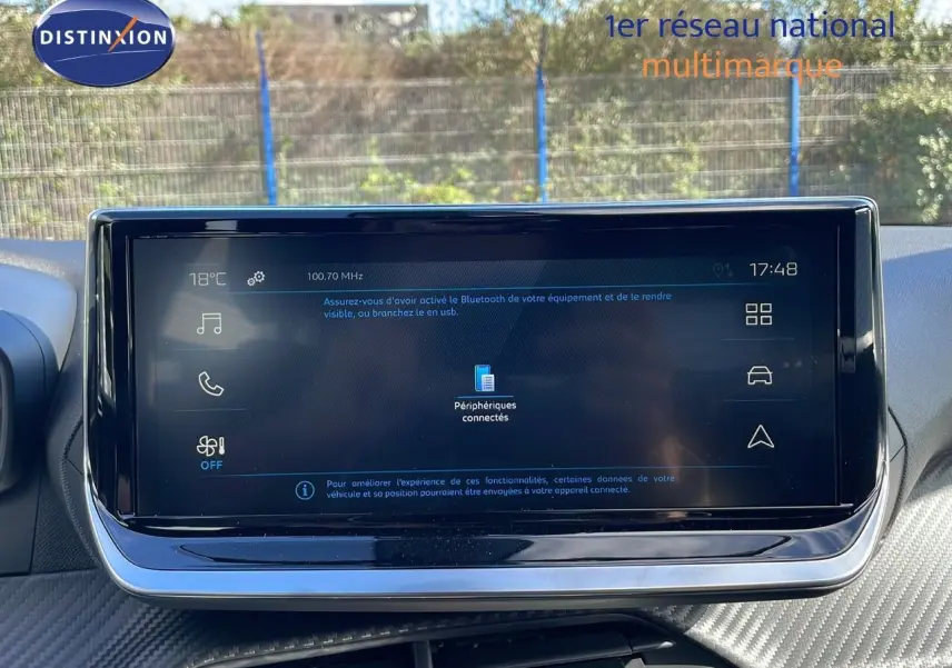 Écran tactile central du tableau de bord du Peugeot 2008 blanc, affichant les options multimédia et connectivité Bluetooth.