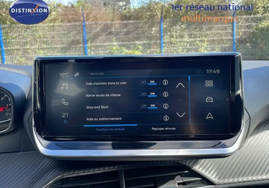 Écran tactile central affichant les aides à la conduite dans l'habitacle du Peugeot 2008 blanc côté conducteur.