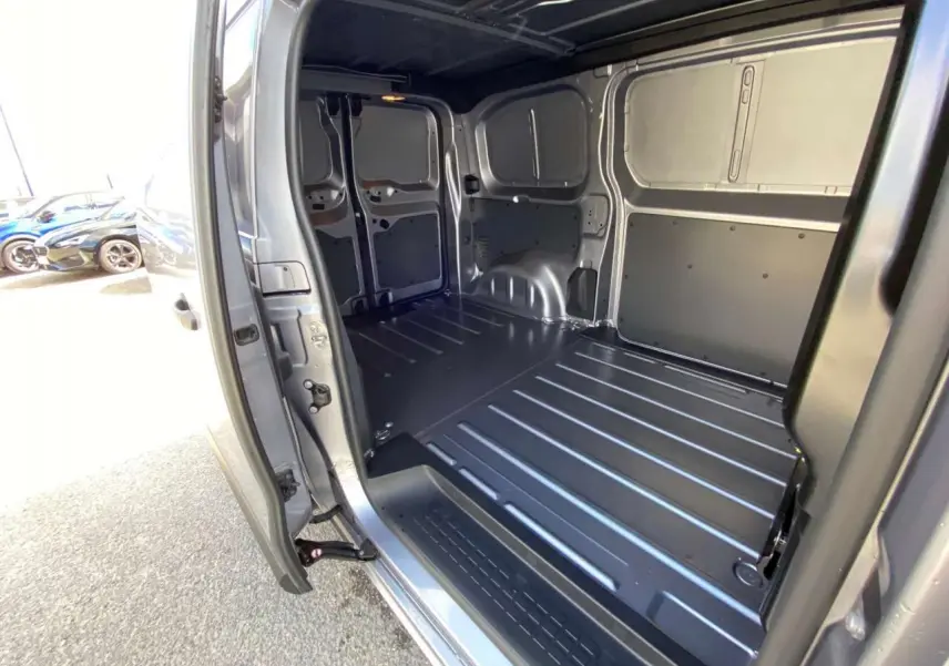 Vue intérieure du coffre arrière ouvert du Peugeot Expert Fourgon gris Artense Métal, montrant l'espace de chargement métallique.