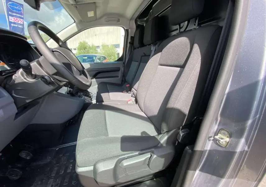 Vue intérieure côté conducteur du Peugeot Expert Fourgon gris Artense, montrant la banquette passager 2 places Moduwork et le volant réglable.