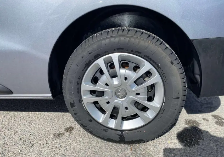 Gros plan sur la roue avant droite du Peugeot Expert Fourgon gris Artense métallisé avec enjoliveur d'origine.