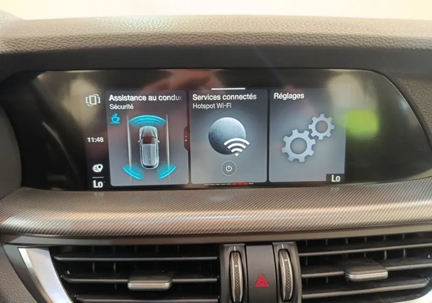 Écran tactile central affichant l'assistance à la conduite, services connectés et réglages dans l'Alfa Romeo Stelvio 2024.