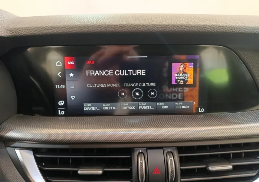 Écran tactile central du tableau de bord gris foncé de l'Alfa Romeo Stelvio Sprint 2024 affichant une radio DAB.