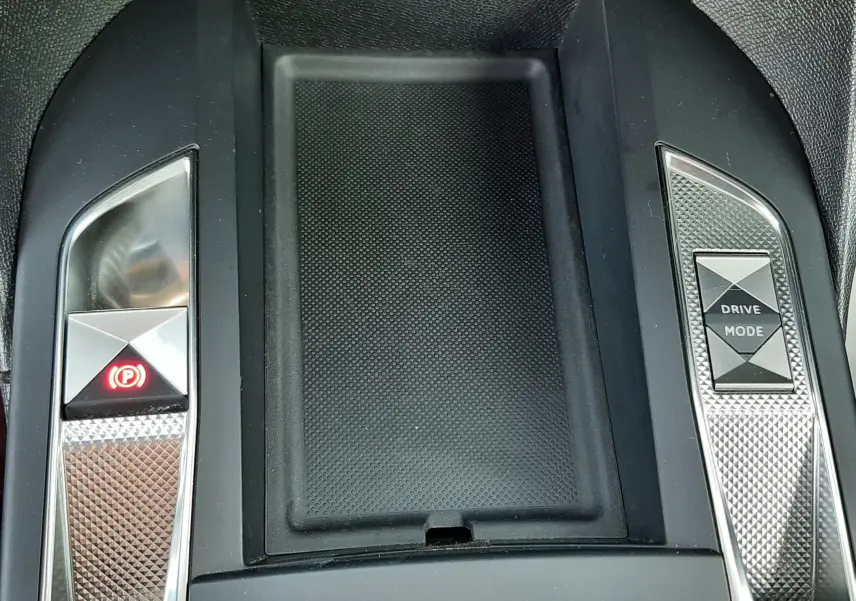 Vue rapprochée de la console centrale noire du DS3 Crossback 2019 avec boutons frein à main et mode de conduite.