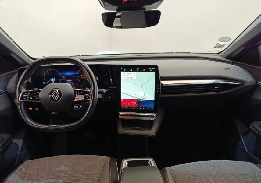 Vue intérieure avant de la Renault Mégane Techno EV60 220ch avec tableau de bord moderne et écran tactile vertical.
