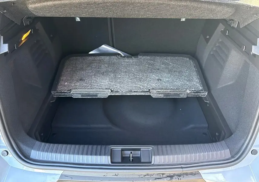 Vue plongeante sur le coffre ouvert gris rafale du Renault Symbioz 2026 avec plancher de coffre mobile visible.