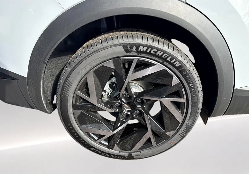 Gros plan sur la roue avant droite avec jante alu noire au design géométrique du Renault Symbioz gris rafale.