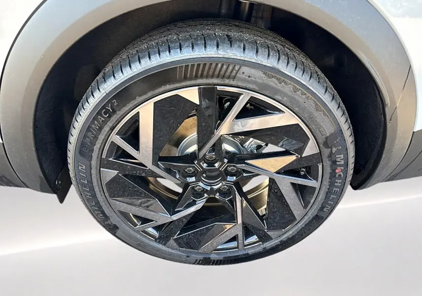 Gros plan sur la jante alu noire et argentée du côté gauche du Renault Symbioz gris rafale, pneu Michelin visible.