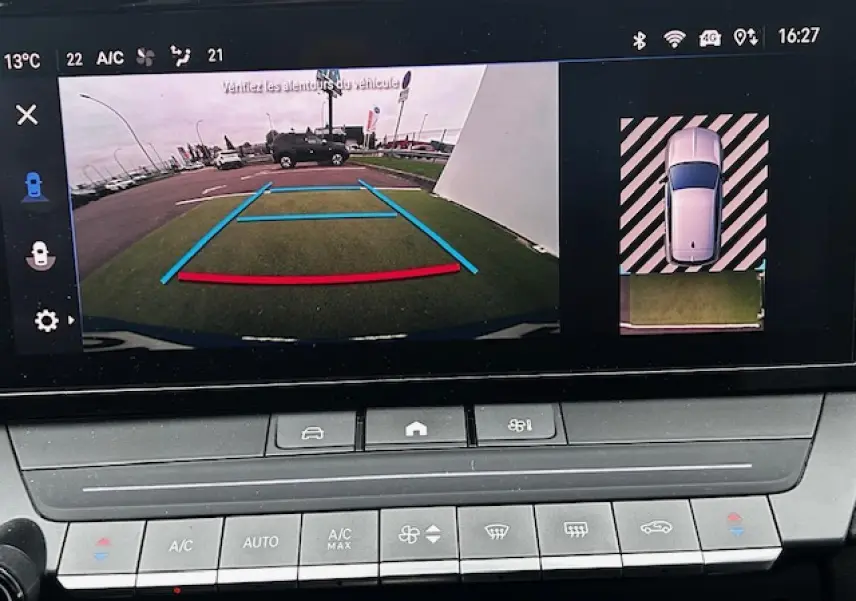 Écran multimédia montrant la caméra de recul de l'Opel Astra bleu clair, avec vue arrière et guidage de stationnement.