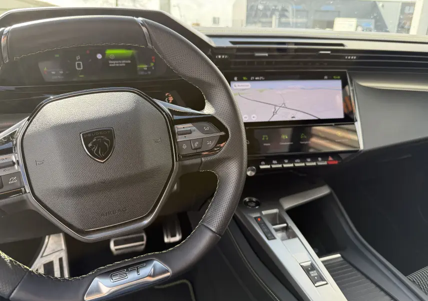 Vue intérieure du poste de conduite de la Peugeot 308 SW BlueHDi 130 GT avec volant GT et écran tactile central.