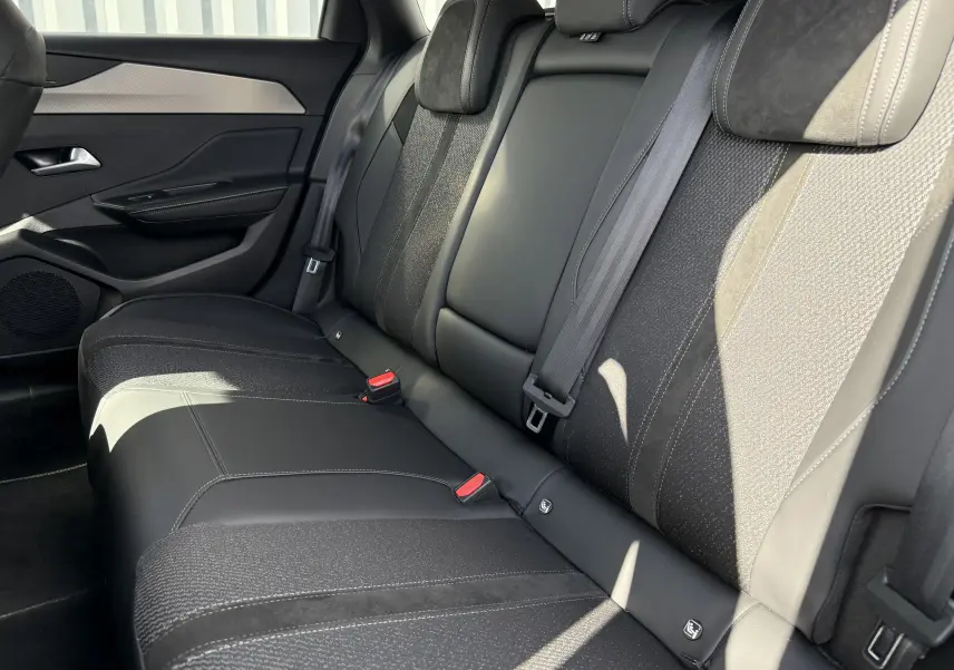 Vue latérale droite des sièges arrière en cuir et tissu noir de la Peugeot 308 SW BlueHDi 130 EAT8 GT 2024.