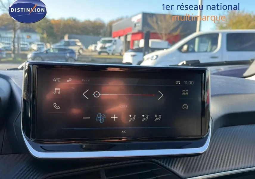 Écran tactile central du tableau de bord de la Peugeot 208 gris Artense, affichant les commandes de climatisation.