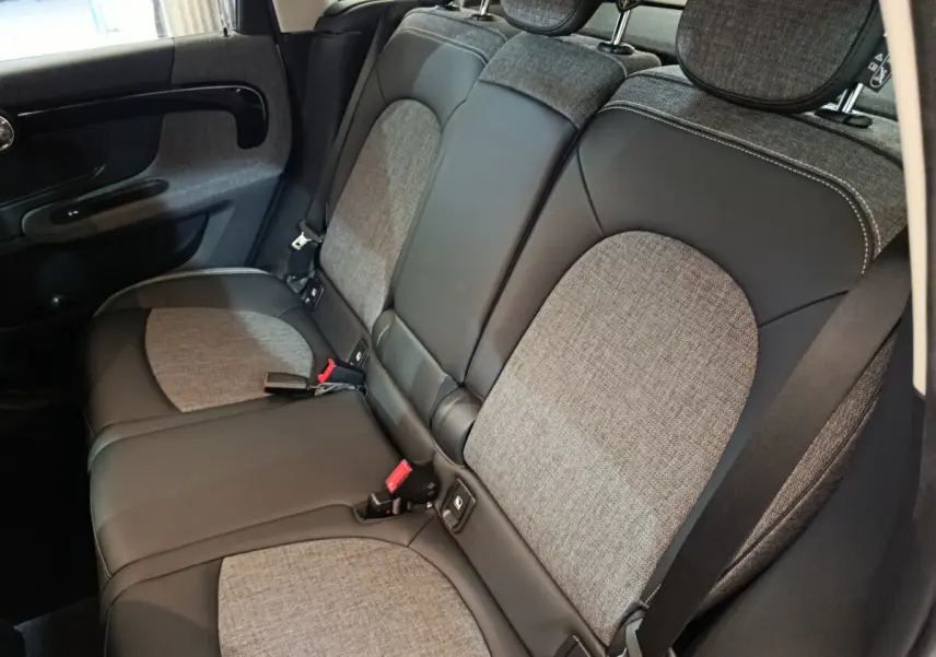 Vue intérieure côté droit des sièges arrière gris et noir du MINI COUNTRYMAN Cooper SE 2021, avec ceintures de sécurité visibles.