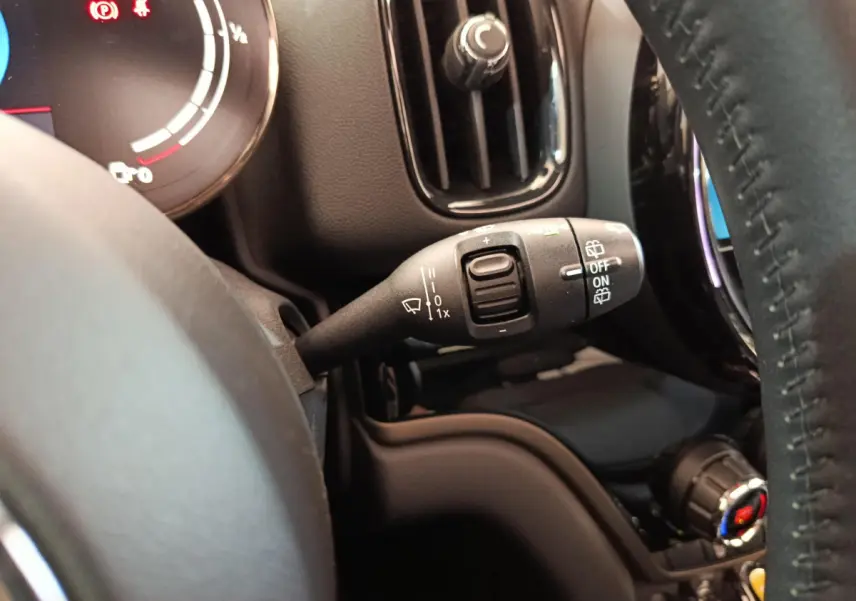 Gros plan sur la commande d'essuie-glace à gauche du volant cuir noir du MINI Countryman blanc hybride rechargeable.