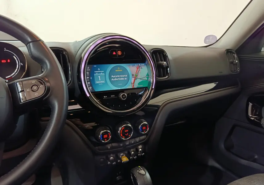 Intérieur de MINI Countryman Cooper SE 2021, vue du tableau de bord avec écran tactile rond et commandes climatisation.