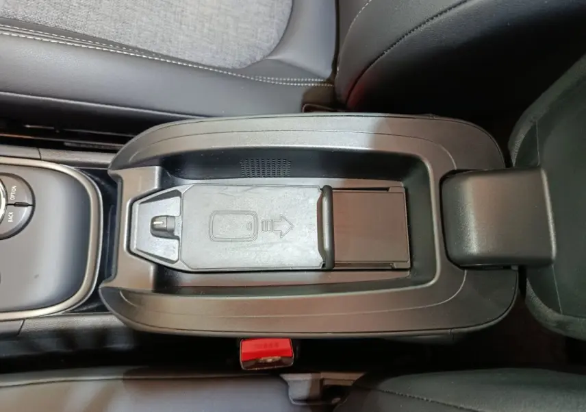 Vue plongeante sur la console centrale noire du MINI Countryman blanc, avec compartiment de rangement fermé.