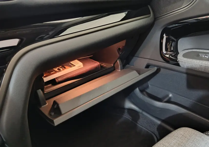 Gant de boîte à gants ouvert côté passager du MINI Countryman blanc, montrant un manuel et un éclairage intérieur.