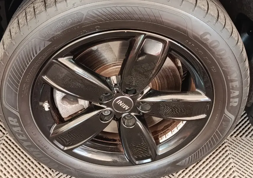 Gros plan sur la jante noire brillante et le pneu Goodyear d'un MINI Countryman blanc hybride rechargeable.