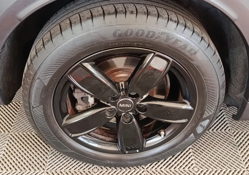 Gros plan sur la roue avant droite d'une MINI Countryman blanche, jante noire brillante et pneu Goodyear.