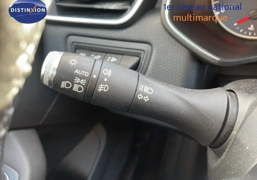 Gros plan sur la commande des feux et clignotants à gauche du volant dans une Renault Clio blanc glacier 2020.