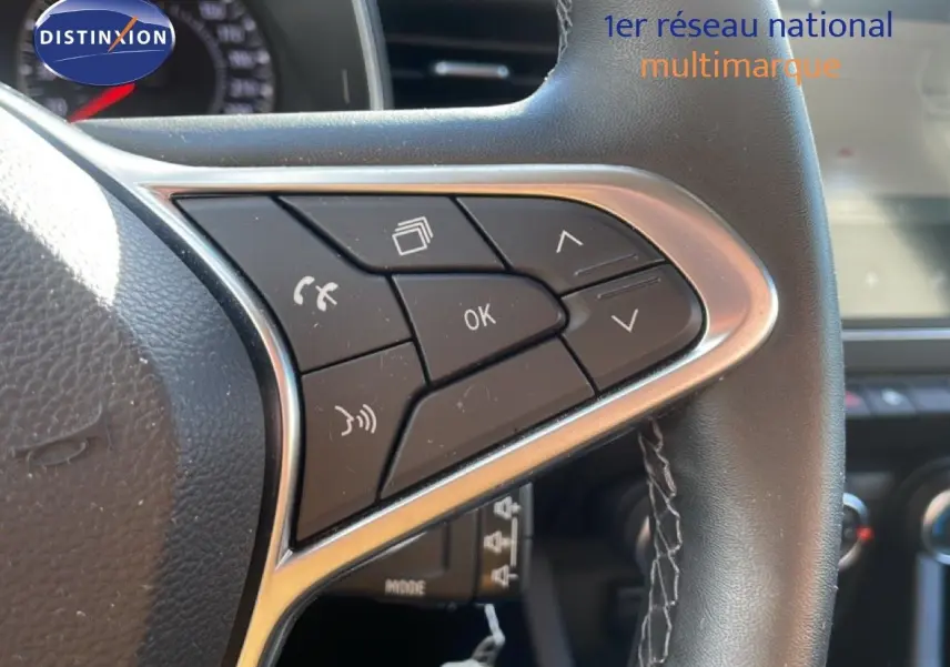 Gros plan sur les commandes au volant côté gauche d'une Renault Clio blanche glacier 2020 essence business.