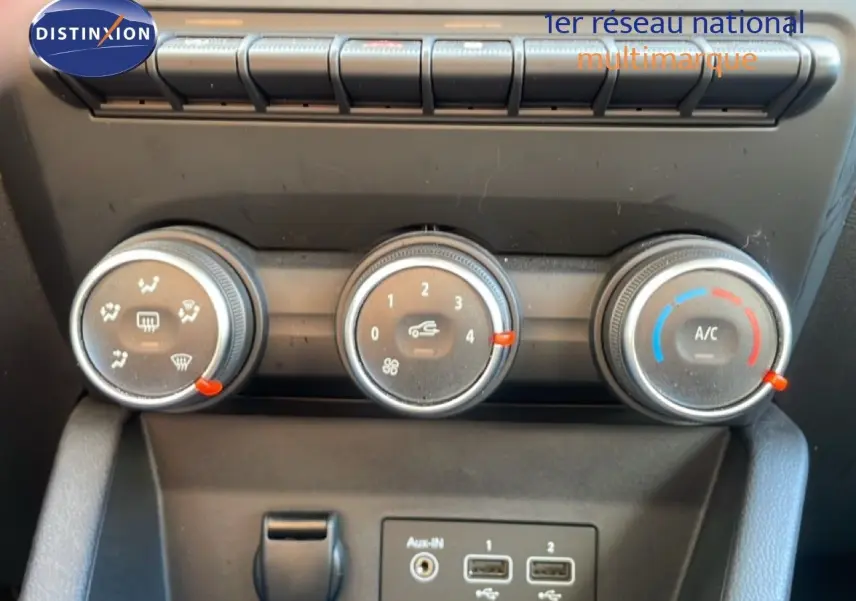 Commandes de climatisation manuelle avec trois molettes et ports USB sur Renault Clio blanc glacier 2020.