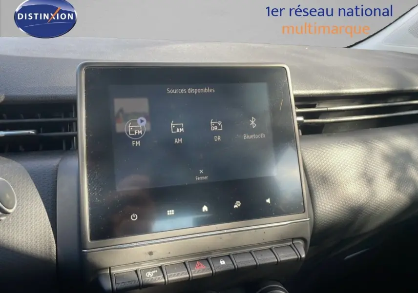 Écran tactile central affichant les sources audio dans l’habitacle d’une Renault Clio blanche glacier 2020.