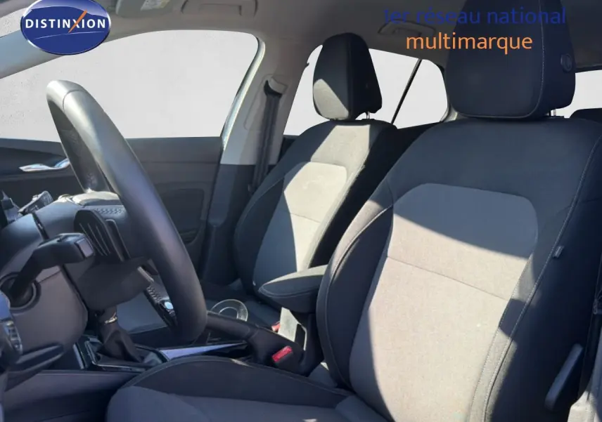 Vue intérieure côté gauche de la Skoda Fabia 2025, sièges tissu noir et gris avec volant cuir multifonction.