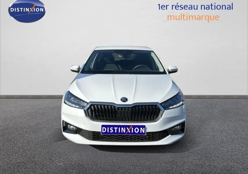 Vue frontale d'une Skoda Fabia blanche glacier avec calandre noire et phares LED allumés sur fond neutre.