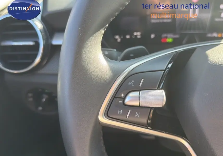 Gros plan sur les commandes gauche du volant cuir de la Skoda Fabia blanche Glacier, avec molette et boutons multifonctions.