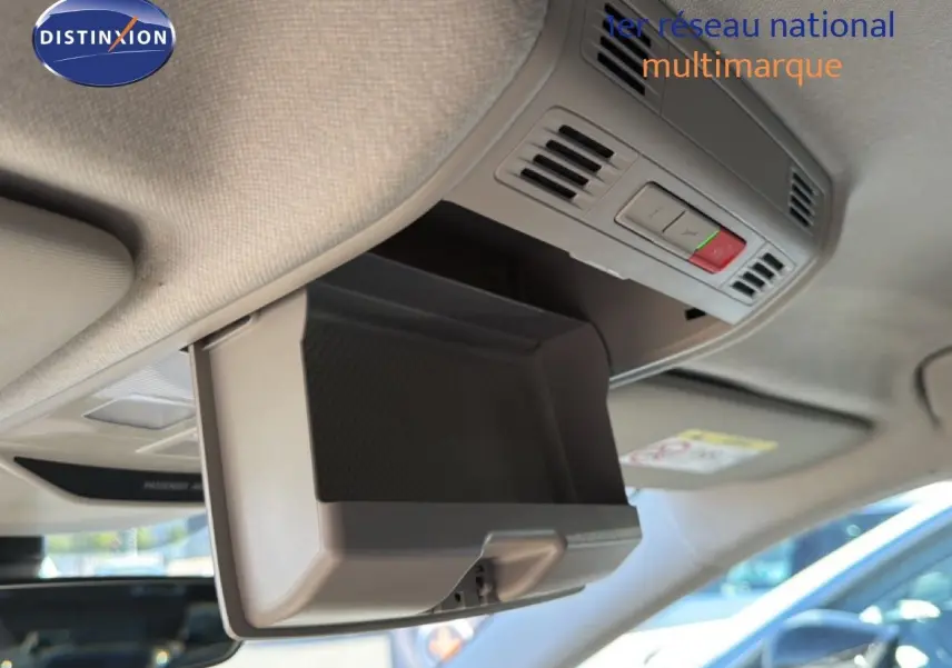Vue intérieure en gros plan du rangement plafond ouvert dans une Skoda Fabia blanc glacier, avec commandes intégrées visibles.