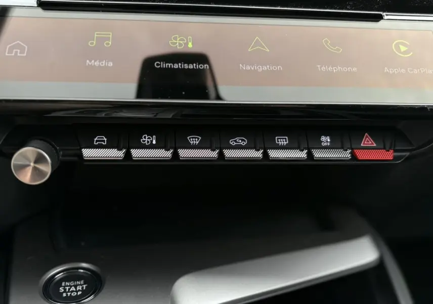 Gros plan sur la console centrale de la Peugeot 308 GT 2024 avec boutons tactiles et écran tactile lumineux.