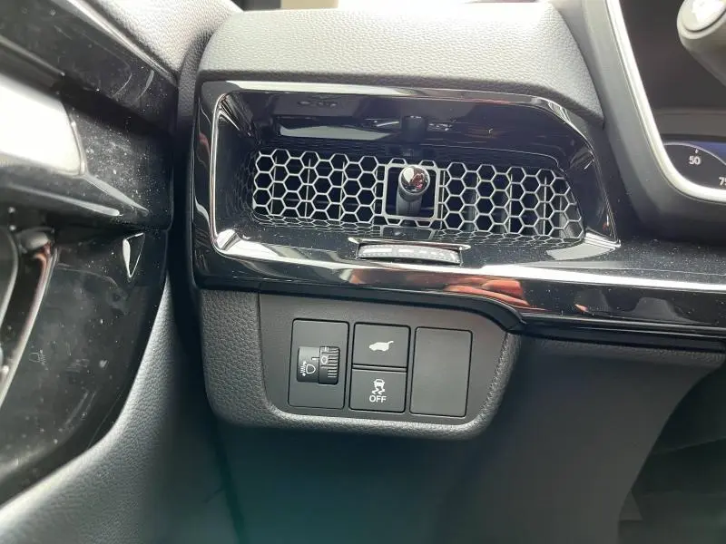 Détail de la console côté gauche avec commandes d'éclairage et ouverture de coffre du Honda CR-V blanc Platine nacrée 2024.