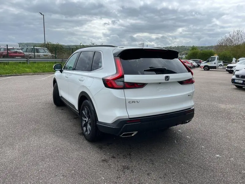 Vue 3/4 arrière droite d'un Honda CR-V 2024 blanc platine nacré avec feux arrière LED et jantes alliage noires.