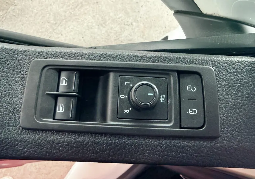 Commande des rétroviseurs et des vitres sur la porte côté gauche d’un Volkswagen Transporter blanc L1H1 2018.