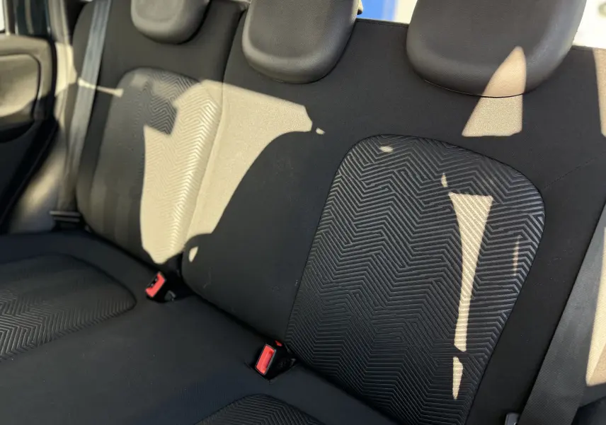 Vue rapprochée des sièges arrière en tissu noir avec motifs géométriques de la Fiat Panda City Cross gris minuit 2023.