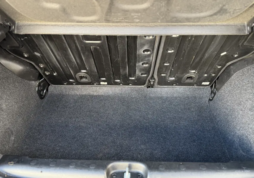 Vue intérieure du coffre vide de la Fiat Panda City Cross 2023, avec revêtement gris et structure métallique apparente.