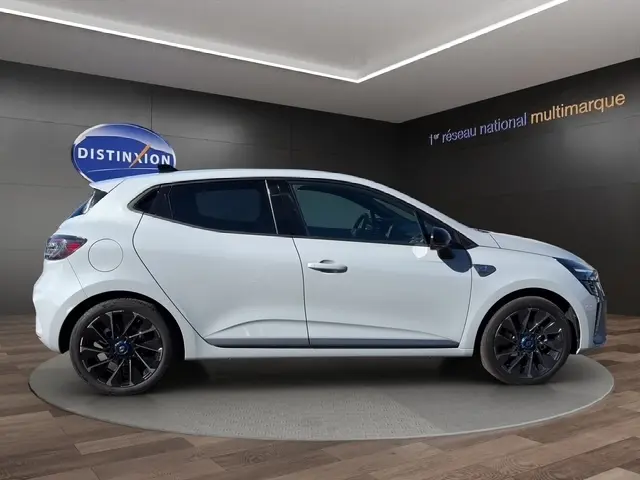 Profil droit d'une Renault Clio Esprit Alpine E-Tech gris clair, avec jantes noires et détails bleus sur les roues.