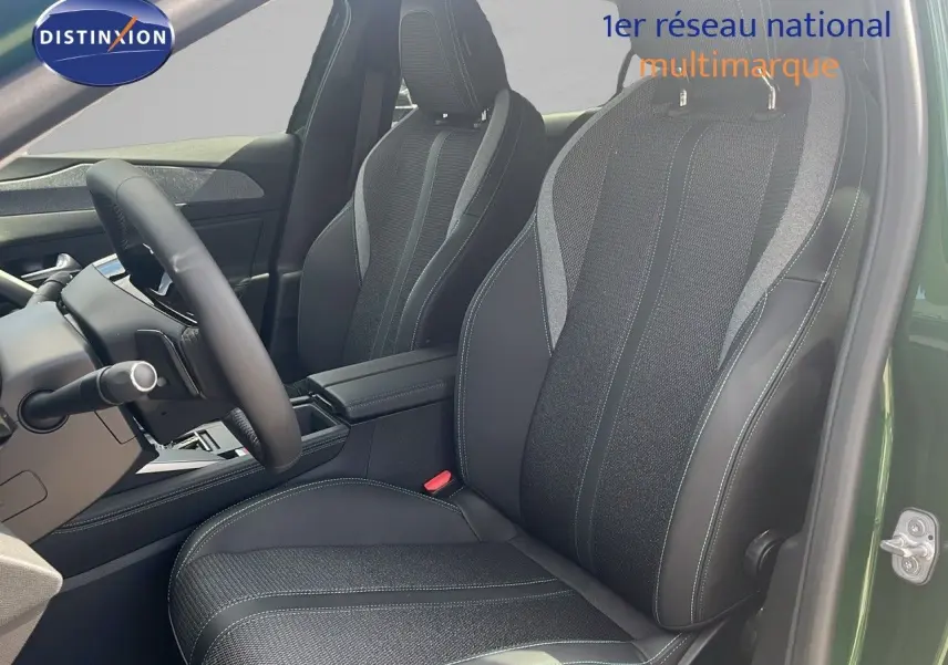 Intérieur de la Peugeot 308 2024, vue côté conducteur, sièges en cuir noir et tissu gris, portière vert olivine métal ouverte.