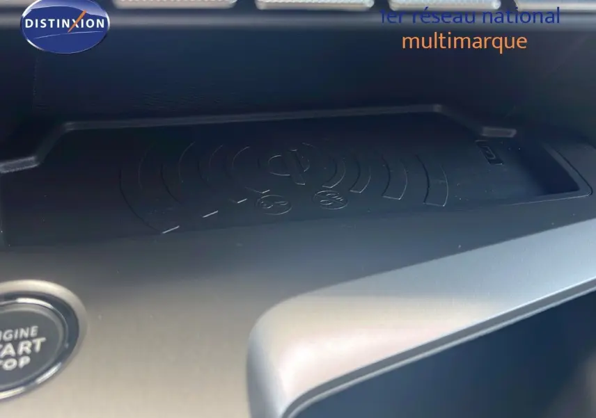 Gros plan sur la zone de recharge sans fil et bouton start/stop du tableau de bord d'une Peugeot 308 verte olivine.