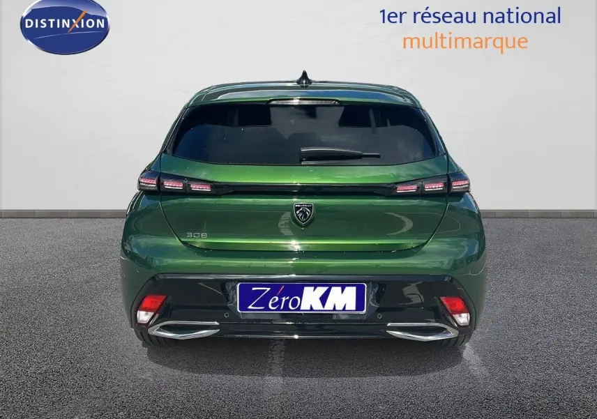 Vue arrière d'une Peugeot 308 hybride 2024 en vert olivine métallisé avec feux LED et double sortie d'échappement chromée.