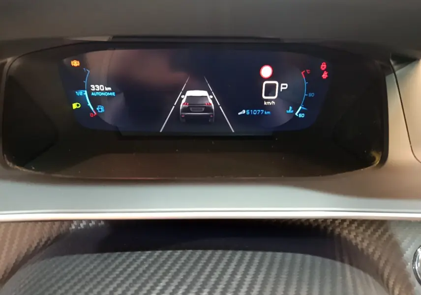Affichage numérique du tableau de bord du Peugeot 2008 gris clair, montrant la vitesse, autonomie et assistance au maintien de voie.